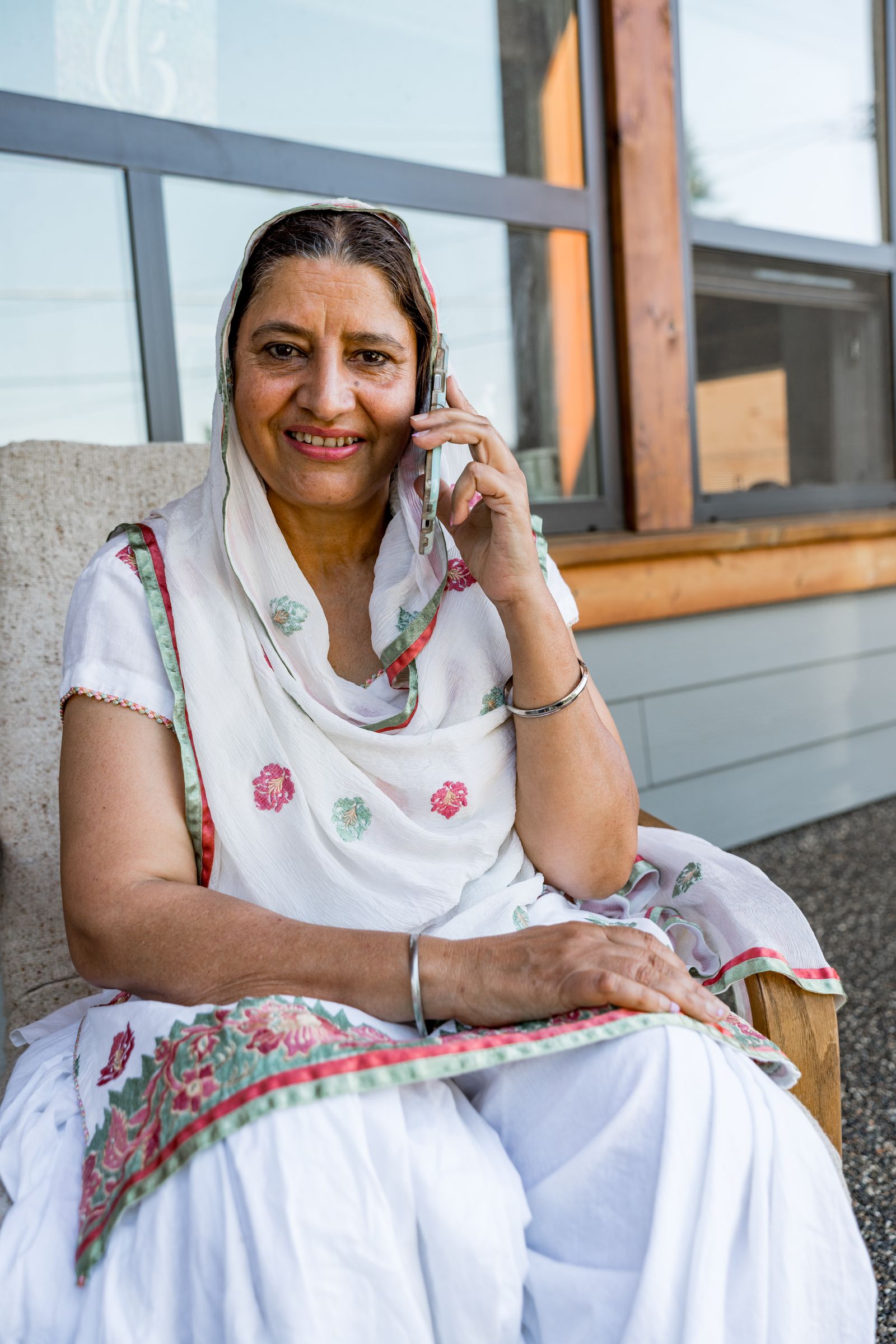 A smiling older woman talking on her phone at home